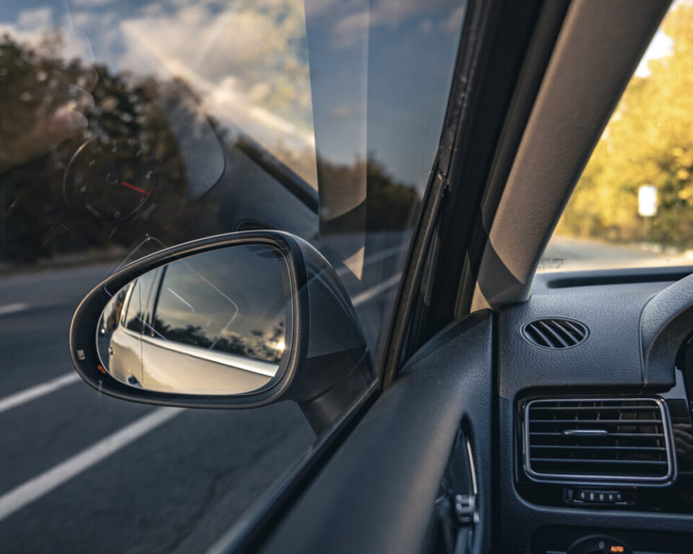 The view of the road in the car's rearview mirror.